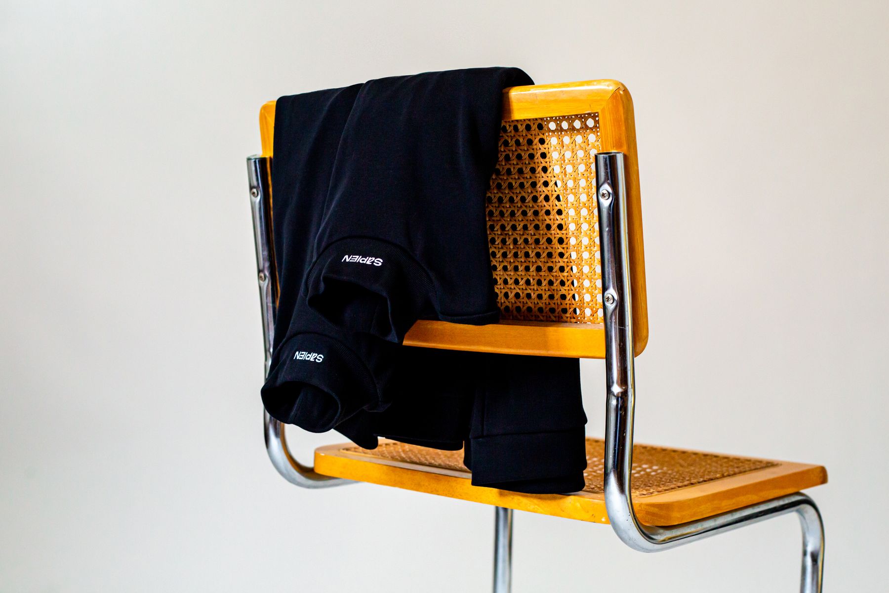 Pull Sapien posé sur le dossier d'une chaise cannée
